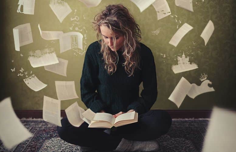 personne en train d'écrire avec des feuilles volantes autour d'elle