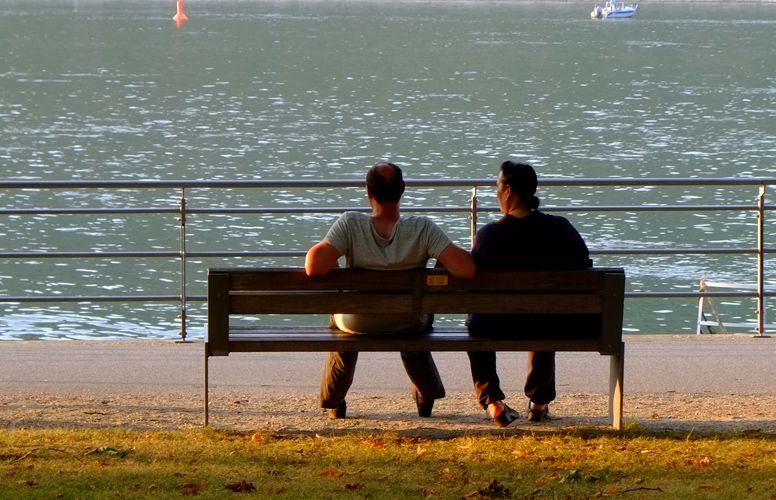 deux hommes parlent sur un banc